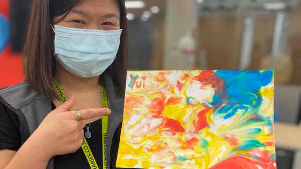 Librarian Yui with a colourful marbled artwork, made using shaving foam and food colouring.