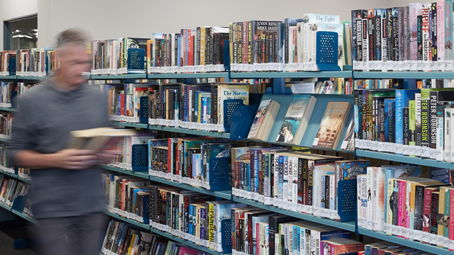 Book shelves with man walking past