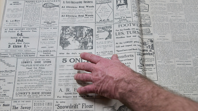 Newspaper with hand pointing