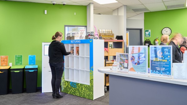 Person placing books on returns shelf