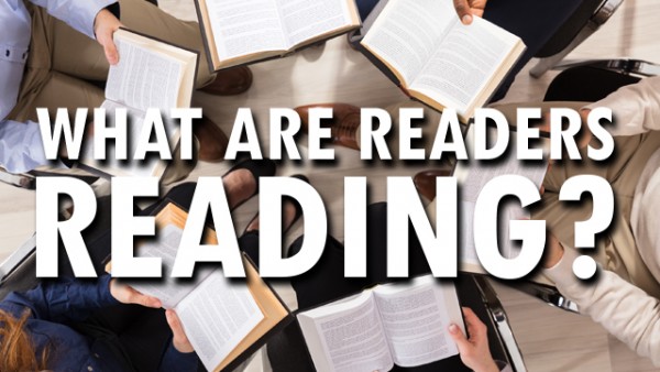 From above, six books are held open in the laps for six different people, in a circle formation. The text What are readers reading? is overlaid.