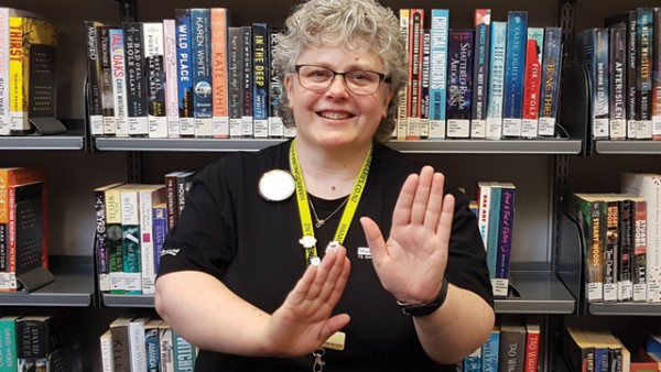 Librarian Nikki signing New Zealand in New Zealand Sign Language.